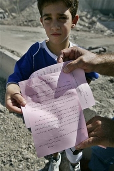 A Lebanese boy shows a leaflet distributed by Hezbollah supporters