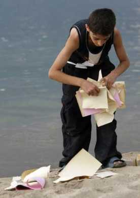 A young Lebanese boy collects Israeli air-dropped leaflets in Beirut. 