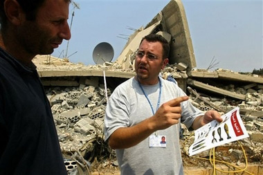 Elias Kayyal, an officer of the United Nations Mine Action Coordination Center holds a leaflet depicting unexploded ordinance in the village of Al Bayyadah, southern Lebanon