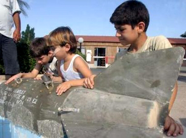Lebanese children inspect a leaflet bomb that was dropped in Sidon, south Lebanon, July 24, 2006. REUTERS/Ali Hashisho