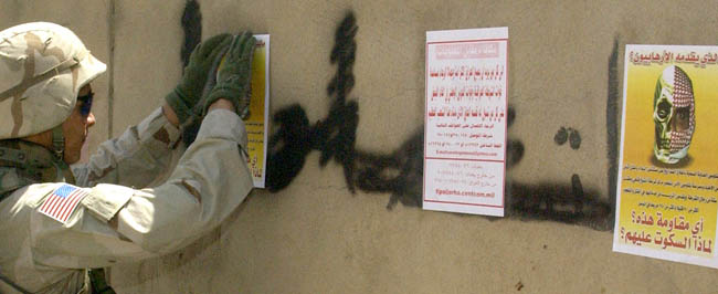 Iraq: Posters cover insurgent graffiti.